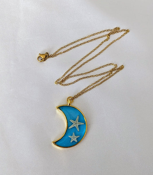 Collier fait main avec un coquillage incrusté dans la résine – bijou nature et bord de mer. En forme de lune