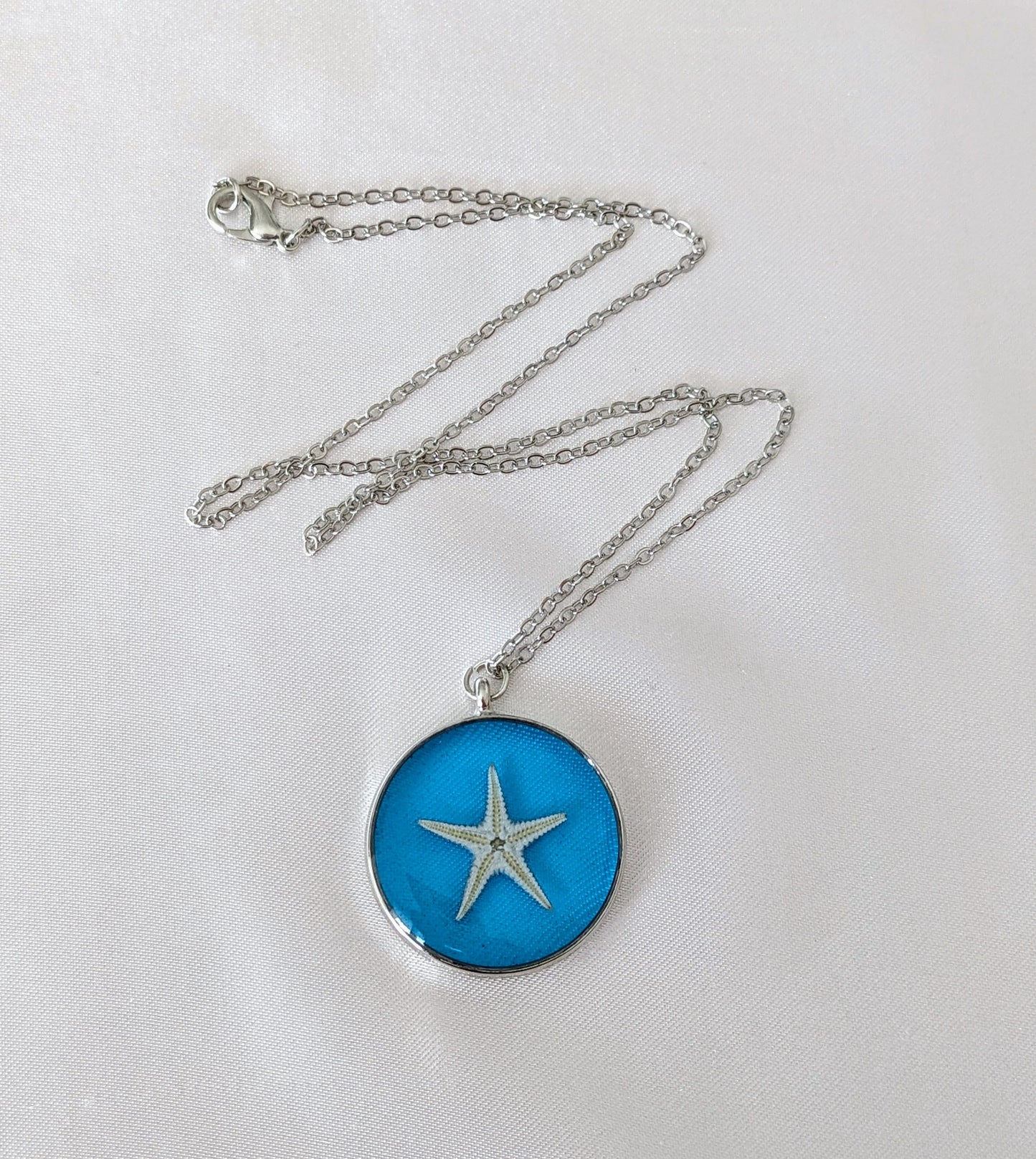Collier fait main avec un coquillage incrusté dans la résine – bijou nature et bord de mer.