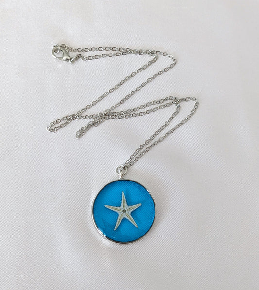 Collier fait main avec un coquillage incrusté dans la résine – bijou nature et bord de mer.
