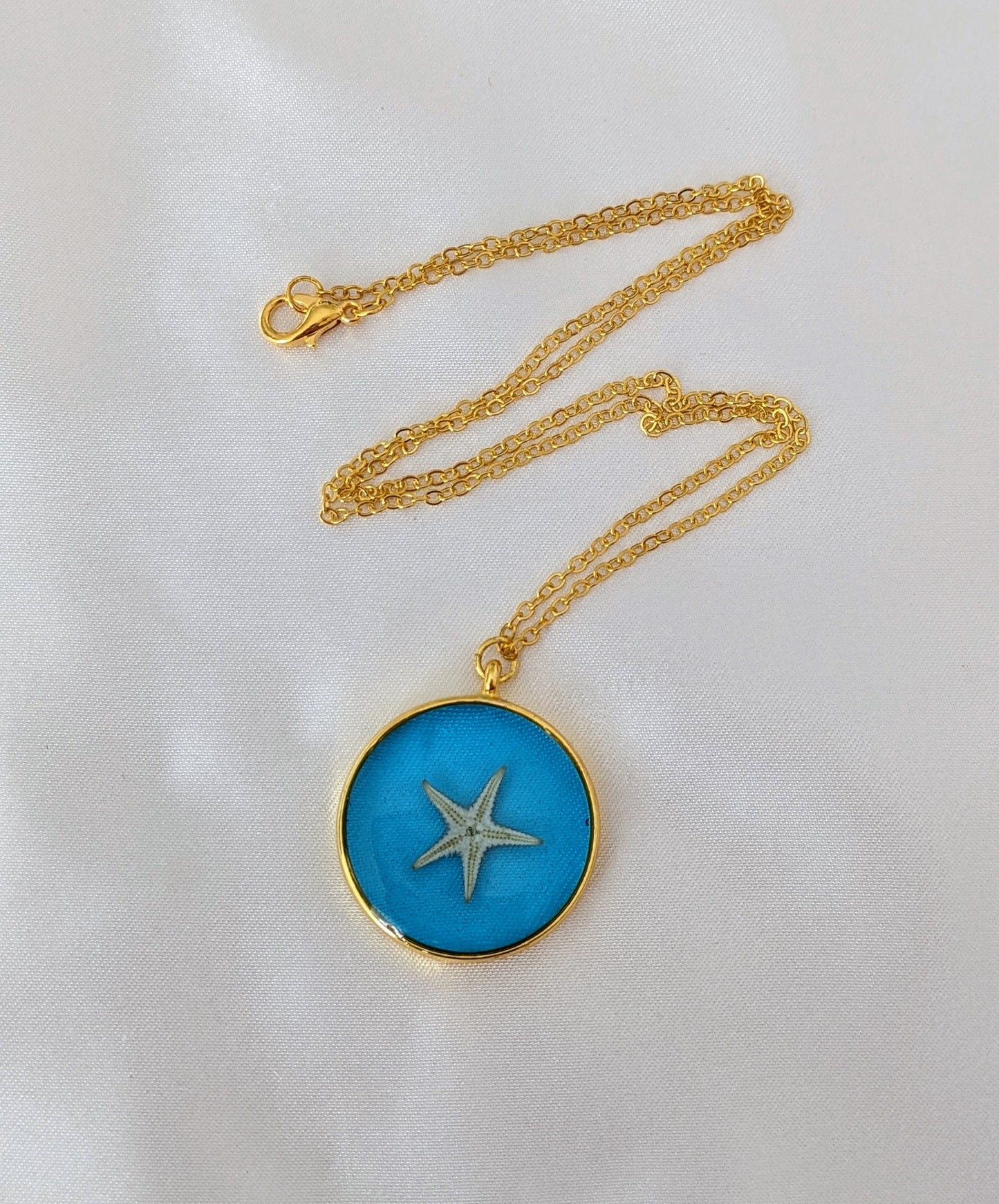 Collier fait main avec un coquillage incrusté dans la résine – bijou nature et bord de mer.