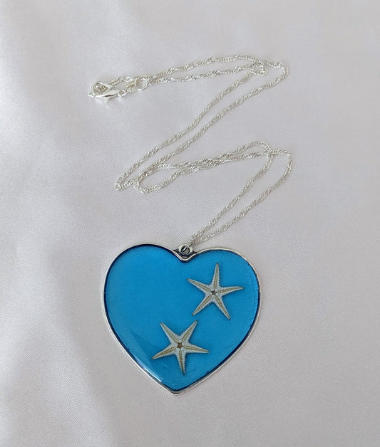 Collier fait main avec un coquillage incrusté dans la résine – bijou nature et bord de mer. En forme de cœur