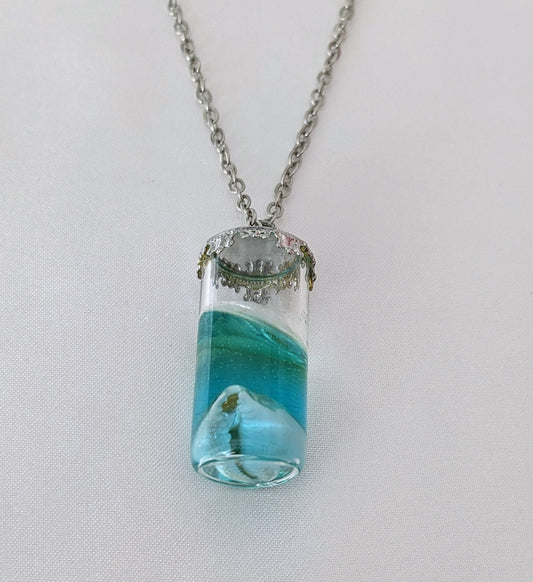 Collier fiole fait main avec un coquillage incrusté dans la résine – bijou nature et bord de mer.