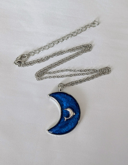 Collier fait main avec un dauphin incrusté dans la résine – bijou nature et bord de mer. En forme de lune