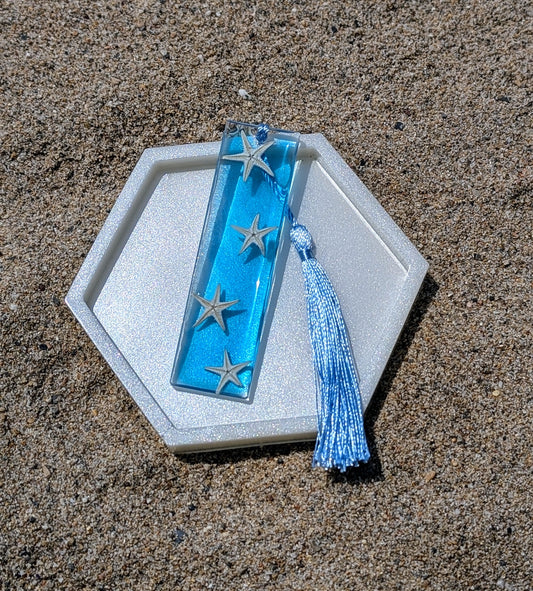 Marque-page artisanal en résine avec coquillages et sable – thème océan, fait main en France.