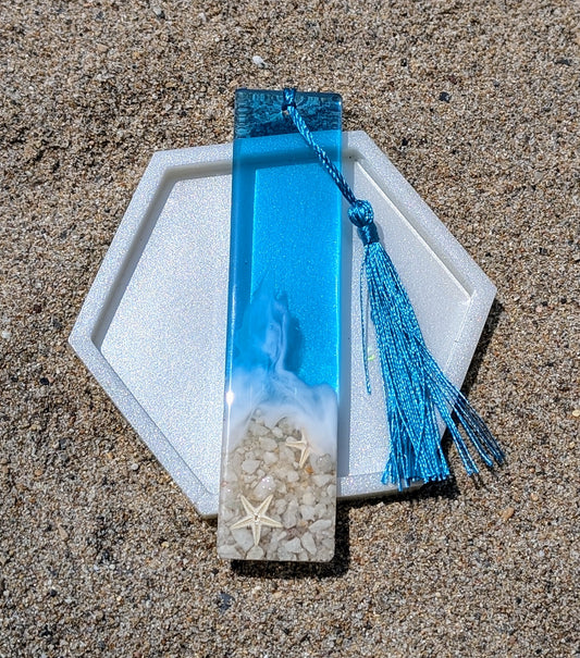 Marque-page artisanal en résine avec coquillages et sable – thème océan, fait main en France.