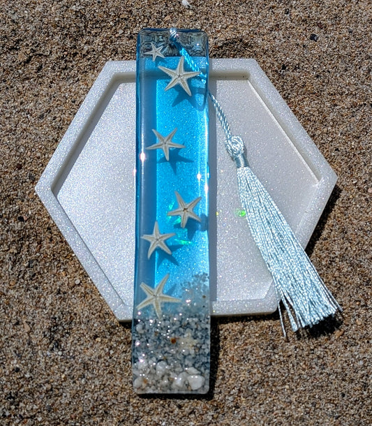Marque-page artisanal en résine avec coquillages et sable – thème océan, fait main en France.