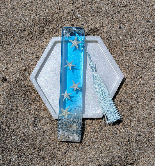 Marque-page artisanal en résine avec coquillages et sable – thème océan, fait main en France.