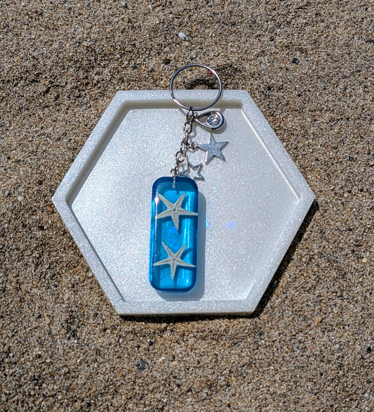 Porte-clé artisanal en résine avec coquillages naturels, thème bord de mer, fait main en France.
