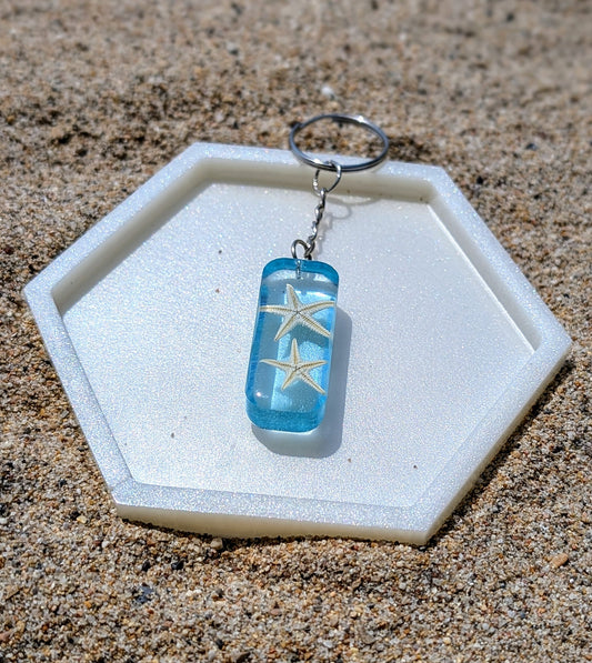 Porte-clé artisanal en résine avec coquillages naturels, thème bord de mer, fait main en France.